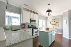 a kitchen with white cabinets and wood floors