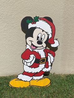 a mickey mouse christmas decoration sitting in the grass