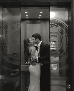 a man and woman kissing in front of a glass door with the seal of the united states on it