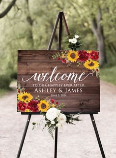 a welcome sign with sunflowers, roses and greenery is on an easel