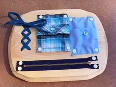 three different types of shirts on a wooden tray with blue and white zippers around them