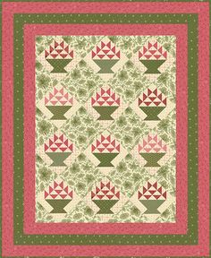 a green and pink quilt with flowers on the front, two rows of blocks in the middle