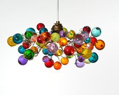 a multicolored chandelier hanging from a ceiling in the shape of balls