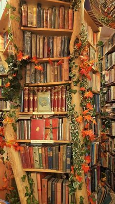 a bookshelf filled with lots of books next to a wall covered in flowers