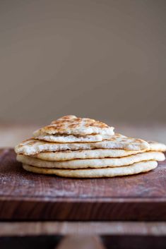 a stack of pancakes sitting on top of a wooden cutting board