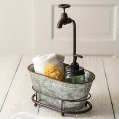 a soap dispenser sitting on top of a wooden floor next to a towel