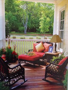 a porch with rocking chairs and pillows on it