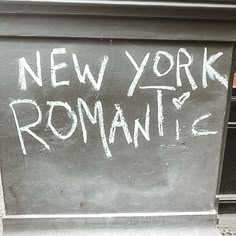 a sign that says new york romantic on the side of a building with graffiti written on it