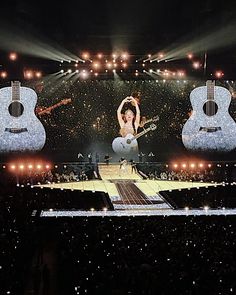 the stage is lit up with two guitars and one woman in front of them on it