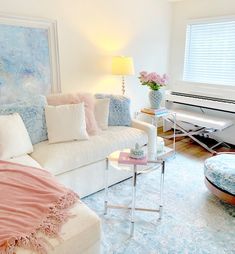 a living room filled with furniture and a white piano in the middle of the room