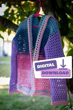 a crocheted shawl hanging from a tree with a sign that reads digital