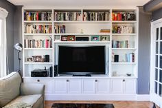 a living room filled with furniture and a flat screen tv mounted on a wall next to a window