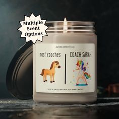 a candle that is sitting on a table with the words coach sarah in front of it