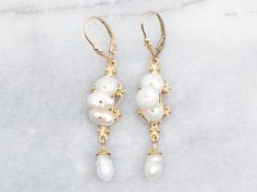 Add a touch of whimsy to your outfit with these drop earrings. Made with natural-shaped pearls on a yellow gold setting, these earrings are perfect for any occasion. Shine bright with these playful and elegant drop earrings! Metal: 14K Yellow Gold Gem: 8 Pearls Gem Measurements: 7.4 x 7.8 mm, Natural Shape Measurements: 11 x 55 mm SKU #: A39661 Each piece has been identified and graded by a Graduate Gemologist who has been certified by the Gemological Institute of America (GIA). We have six brick-and-mortar storefronts in Maine, Massachusetts, and New Hampshire and have been in business for over 25 years! Please visit our Shop's About Page or our website for more information about our jewelry. For questions about diamond grading, we recommend the  Gemological Institute of America (GIA), th Drop Earrings Pearl, Earrings Pearl Drop, Pearl Drop Earrings Gold, Drop Earrings Gold, Gold Pearl Earrings, Earrings Metal, Yellow Gold Setting, Earrings Pearl, Pearl Drop Earrings