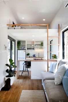 a living room filled with furniture next to a kitchen