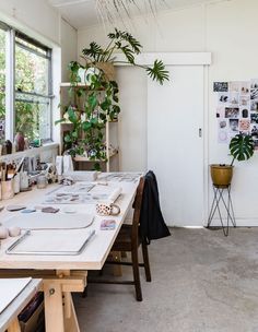 a table with plants and other items on it in a room that has white walls