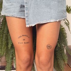 the legs of a woman with tattoos on them and words written in black ink behind her