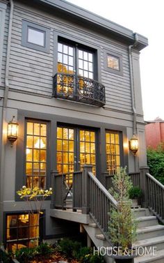 an exterior view of a house with stairs leading up to the front door and windows