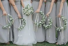 the bride and her bridesmaids are holding their bouquets with ribbons around them