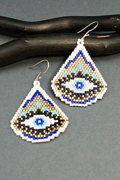 two pairs of beaded earrings with an evil eye on them