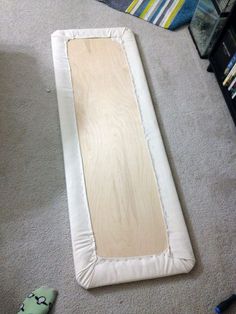 a wooden board laying on the floor next to a blanket