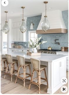 a kitchen with white cabinets and wooden stools next to an island in the middle