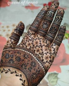 the hand is decorated with intricate designs on it's fingers and palm, as well as flowers