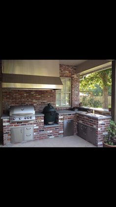 an outdoor kitchen with grill, sink and oven on the outside side of the house