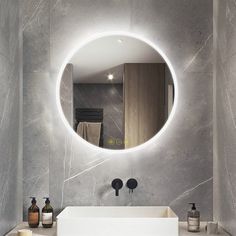 a bathroom with a round mirror above the sink