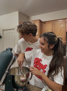 two young people in the kitchen making something to use as a mixer and mixing bowl