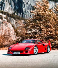 a red sports car parked in front of a mountain