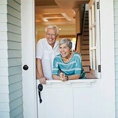 an older couple standing in the doorway of their home