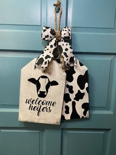 a welcome door hanger with a cow print on it