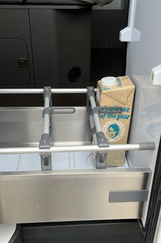 an open drawer in the back of a vehicle with a carton of tissues and a box