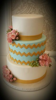 a three tiered cake with flowers on top