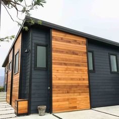 a black and brown house with wood siding