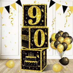 a black and gold 90th birthday cake with balloons in front of the number nine