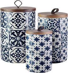 three blue and white ceramic canisters with wooden lids, each decorated with an intricate design