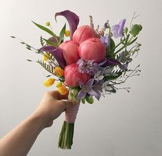 a person holding a bouquet of flowers in their hand