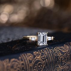 an emerald - cut diamond sits on top of a book