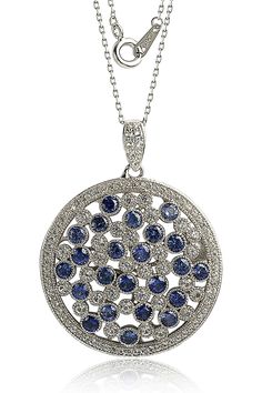 A sterling silver circle pendant necklace is accented with sapphire and crystals. . Sterling silver sapphire and crystal circle pendant necklace. Spring ring. Approx. 18" long. Imported  Please note: Diamond weight may not be exact. Sterling Silver, Sapphire, Created Sapphire Sapphire Jewelry With Sparkling Stones, Round Sapphire Jewelry With Sparkling Stones, Blue Round Jewelry With Pave Setting, Sapphire Round Pendant Jewelry, Blue Round Pendant Jewelry With Diamond Accents, Dazzling Blue Jewelry With Pave Setting, Elegant Blue Circular Jewelry, Dazzling Blue Round Necklace, Dazzling Sapphire Jewelry