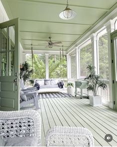 a porch with white wicker furniture and green walls