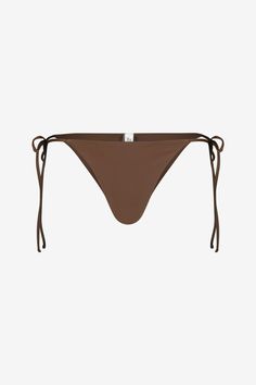 The Bahia bikini top by Sara Cristina features a halter design with a string tie for easy adjusting. The top features a unique Baroque cultivated pearl from Japan. It is accompanied by our classic string bikini bottom. 80% Polyamide, 20% ElastaneMade in USA Sunbathing Swimwear With Drawstring And String Shape, Brown Tie-side Beach Bottoms, Brown Tie-side Bottoms For Beach, Brown Tie-side Bottoms For The Beach, Tie-side Brown Bottoms For The Beach, Adjustable String Tie Swimwear With Tie-side Bottom, Adjustable Tie-side Swimwear With String Tie, Adjustable Tie-side String Tie Swimwear, Summer Brown Swimwear With Tie-side Bottom