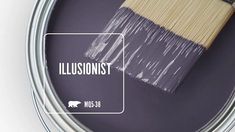 a paint can with the words illusionist painted on it and a brush next to it