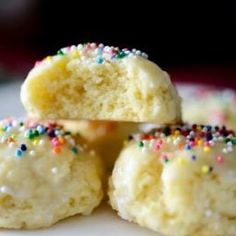 small white cookies with colorful sprinkles on a plate, ready to be eaten