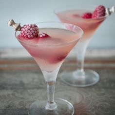 two martinis with raspberries on the rim