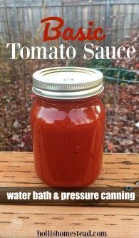 a jar filled with tomato sauce sitting on top of a wooden table next to a garden