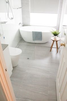 a bathroom with a white bath tub sitting next to a toilet