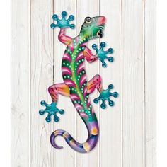 a colorful gecko sitting on top of a wooden wall