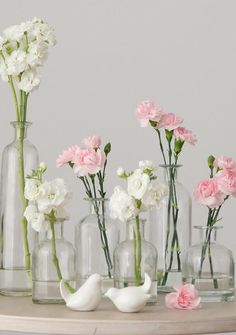 several vases with flowers in them sitting on a table